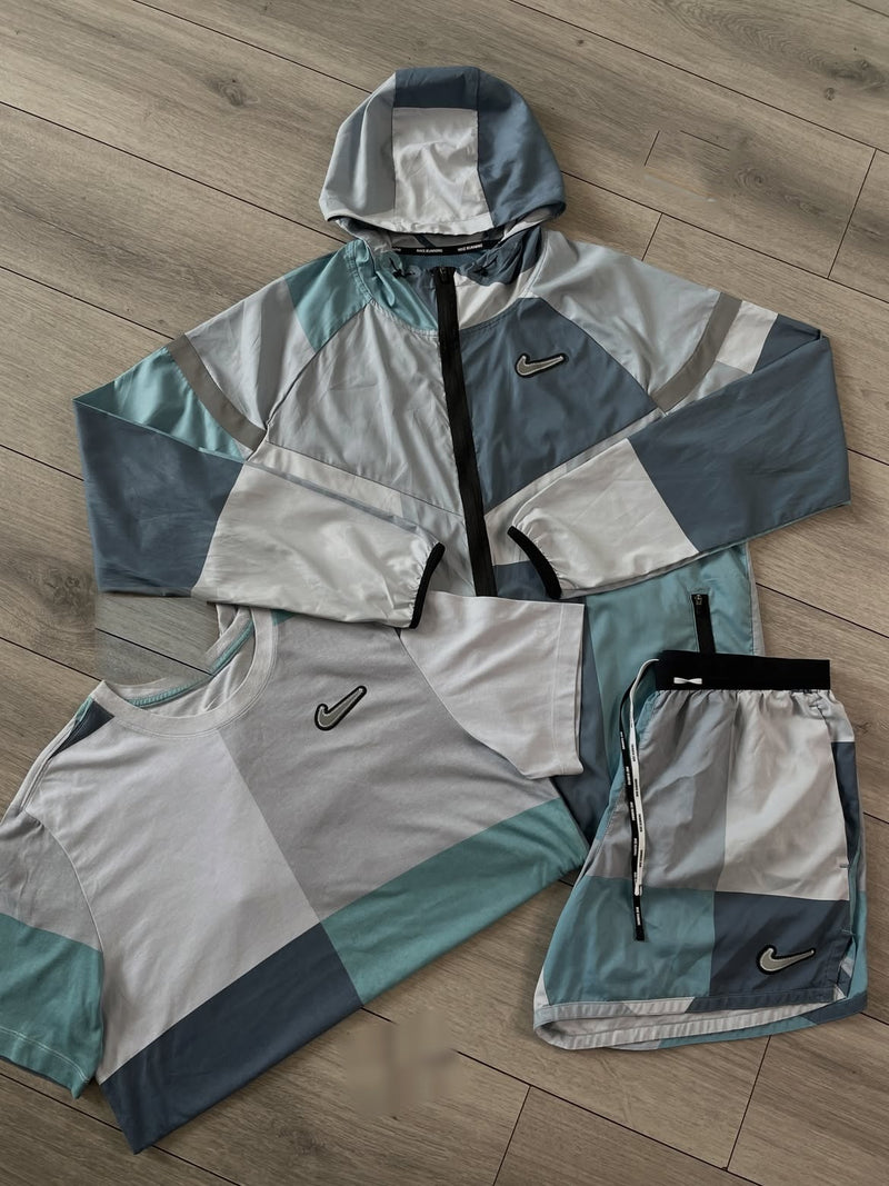 T-shirt et short Nike bleu gris et turquoise avec la veste coupe-vent, vue de dessus rapprochée