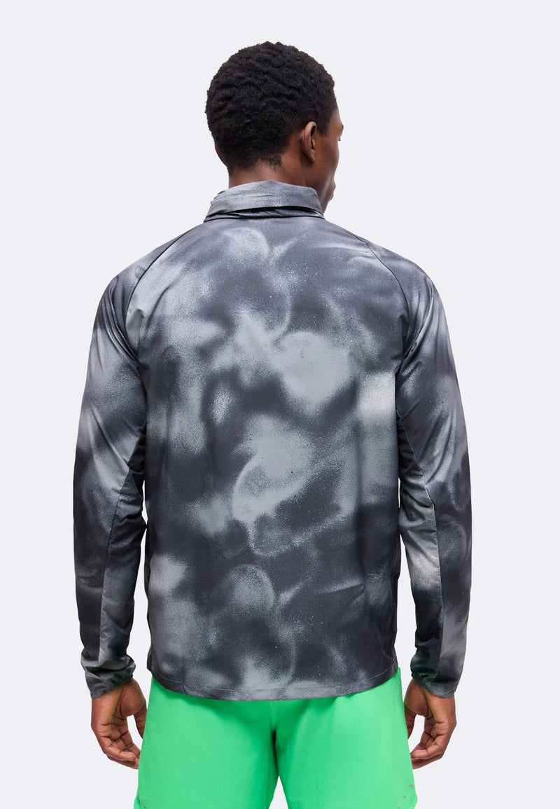 Veste Nike Windrunner grise imprimée vue de dos, portée avec un short de running