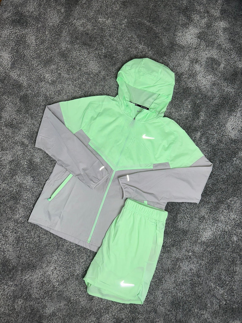 Ensemble running Nike 2 pièces vert menthe et gris : veste à capuche et short posés à plat en diagonale