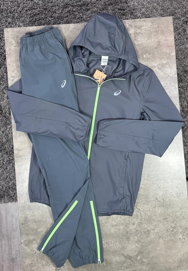 Ensemble survêtement ASICS 2 pièces gris anthracite et vert fluo : veste à capuche zippée et pantalon de jogging à bandes vert fluo, présentés à plat