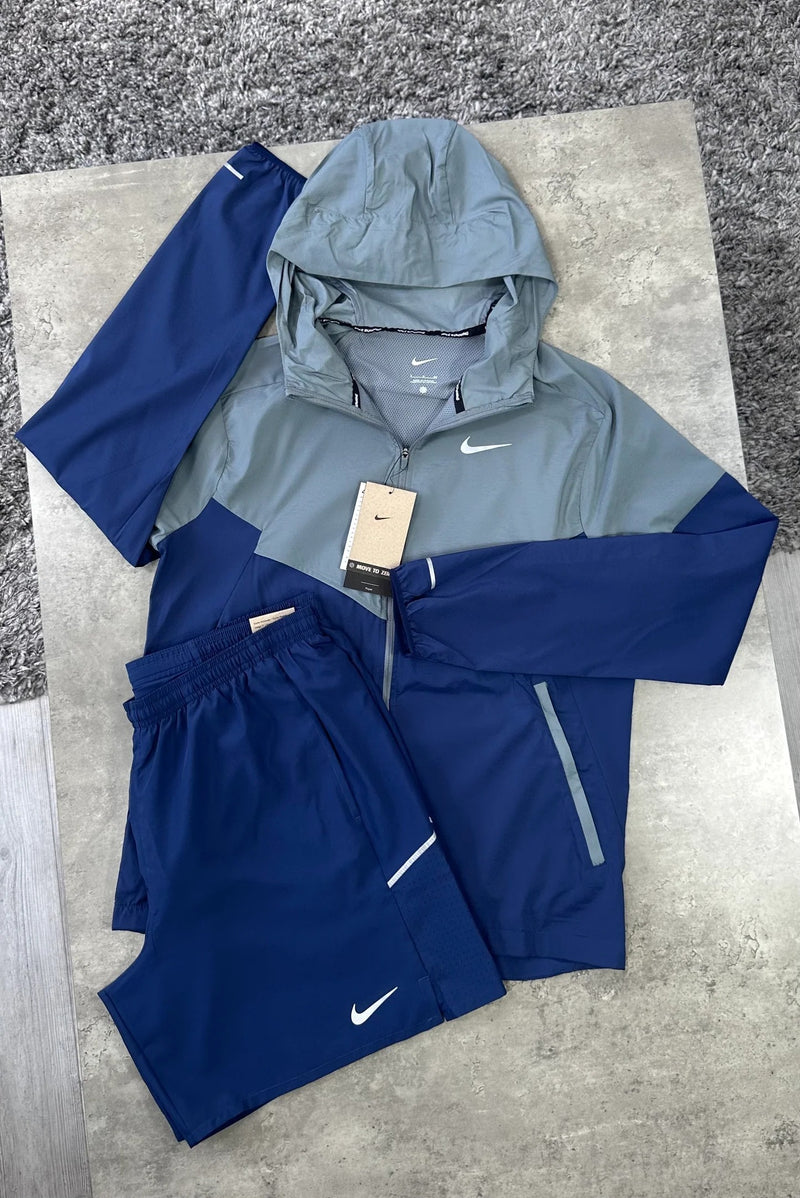 Ensemble running Nike 2 pièces gris sauge et bleu marine : veste coupe-vent à capuche et short posés à plat
